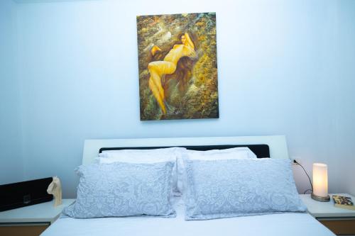 a bedroom with a bed with a painting on the wall at Hana apartament hot tub in Vlorë