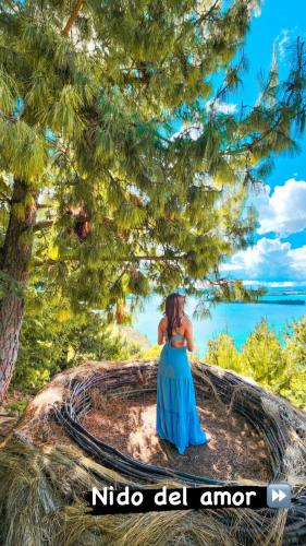 a girl in a blue dress sitting under a tree at Costa Azul Ecolodge in Aquitania