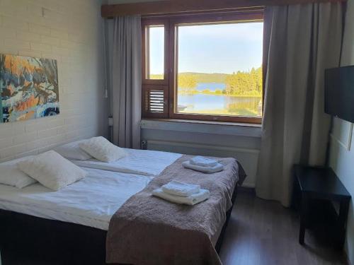 a hotel room with a bed with towels on it at Hotelli Viikinhovi in Keuruu
