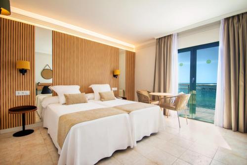 a hotel room with two beds and a balcony at Hotel Servigroup Montíboli in Villajoyosa