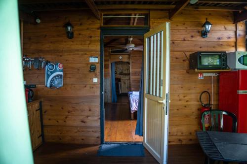 otwarte drzwi do pokoju w drewnianej kabinie w obiekcie Au Dy-Na N°2 w mieście Petite-Île
