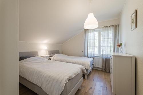 1 dormitorio con 2 camas y ventana en Villa de la Mer holiday home en Kaberneeme