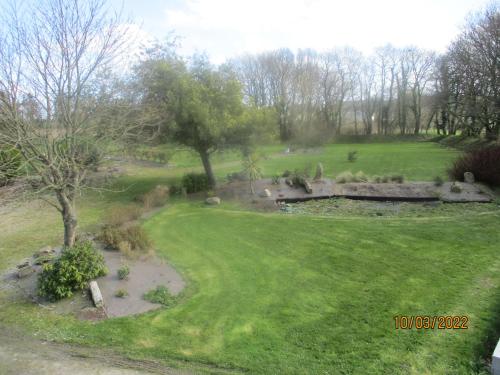 Garlan的住宿－CAMPING VERT DE MORLAIX，享有绿草和树木公园的景致