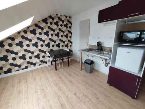 ein Wohnzimmer mit einem Tisch und einer Wand in der Unterkunft Le Clos du Parc Galamé in Loon-Plage
