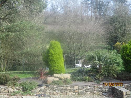 uitzicht op een tuin met een hek en bomen bij CAMPING VERT DE MORLAIX in Garlan