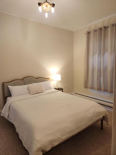 sypialnia z dużym białym łóżkiem i oknem w obiekcie Island View House BnB Self Check-In w mieście Portland