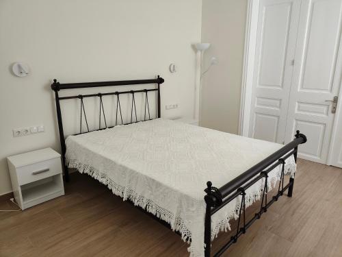 a bedroom with a black bed with a white bedspread at Litseli in Athens