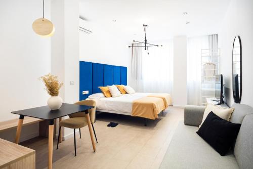 sypialnia z łóżkiem, stołem i kanapą w obiekcie Blanq Marina Suites w Walencji