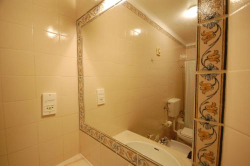 y baño con espejo, bañera y lavamanos. en Jardins do Mar - BY BEDZY, en Albufeira