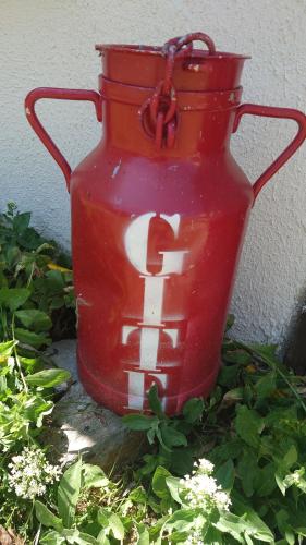 a red vase sitting next to a wall at le marly's in Wasigny