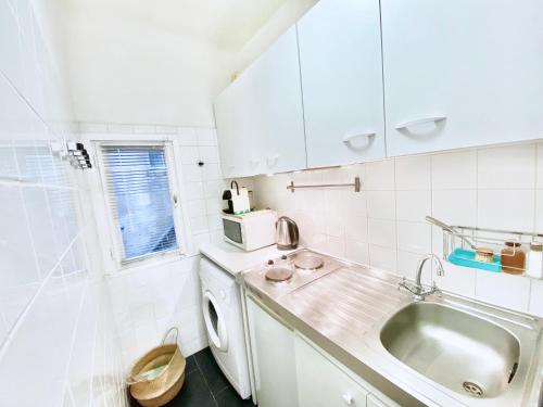 uma cozinha branca com pia e máquina de lavar em CASAJOY, LGLL2, Aix en Provence em Aix-en-Provence