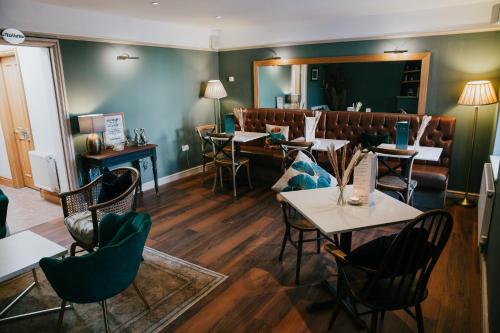 a restaurant with tables and chairs and a mirror at The Limes Hotel in Stratford-upon-Avon