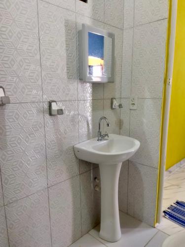 a bathroom with a sink and a tv on the wall at Dunas Bar&Hotel in Canoa Quebrada