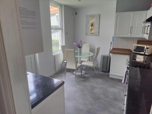 a kitchen with a table and chairs in a room at Bexhill Beautiful Sea Front Bungalow in Bexhill