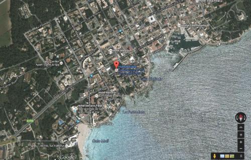 a map of a beach with a red marker at Hotel Baviera in Cala Ratjada