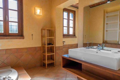 een badkamer met een groot wit bad en een wastafel bij Agriturismo Scaforno Vacanze in Castelnuovo della Misericordia