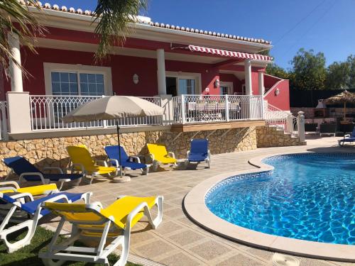 a patio with chairs and a pool and a house at CASA PANORAMICA VUE MER 8 a 10 Personnes in Boliqueime