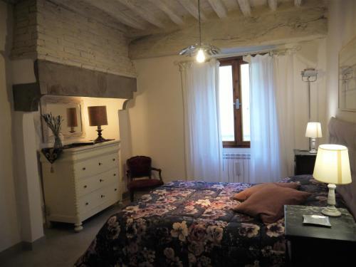 a bedroom with a bed and a dresser and a window at Casa Marzia in Montevarchi