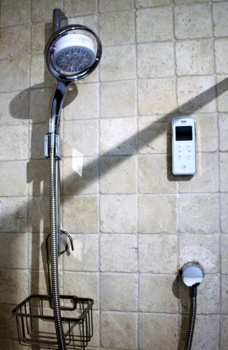 a shower head on a wall with a cell phone at The Roost - Askrigg 18th Century Cottage in Askrigg