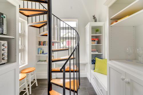 a spiral staircase in a home with white walls at Coastal North Carolina Abode - Rooftop Water Views in Morehead City