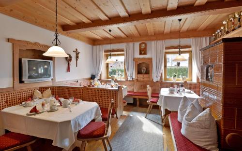 restauracja z dwoma stołami i krzesłami w pokoju w obiekcie Hüttschmiedhof w mieście Kössen