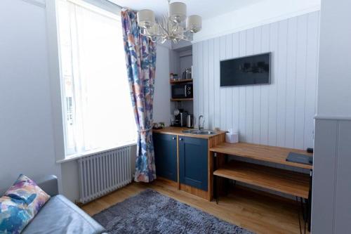 a kitchen with a table and a sink in a room at Ground floor apartment at Number 8: king bed, en-suite, lounge, kitchenette in Kent