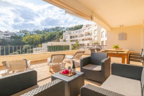 een patio met stoelen en tafels op een balkon bij Marbella Mountain With Sea View And Pool - Happy Rentals in Marbella