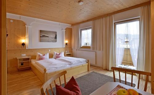 une chambre avec un lit et une table dans une pièce dans l'établissement Hüttschmiedhof, à Kössen