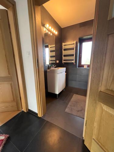 a bathroom with a white sink and a mirror at Dom pod klonami in Szczytno