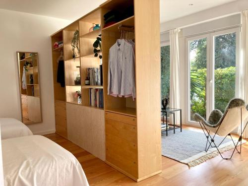 1 dormitorio con cama y estante para libros en Quiet Studio with garden 8 Min from Beach, en Estoril