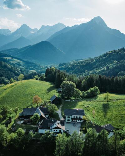 a house in a field with mountains in the background at Ferienhof Mittermair in Vorderstoder