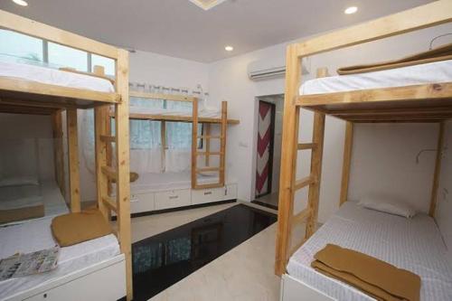 pennywise homestay hostel في مدينة دافاو: غرفة بها ثلاثة أسرة بطابقين ونافذة