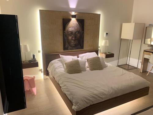une chambre avec un grand lit avec un portrait d'une tête dans l'établissement Maison contemporaine plein centre piscine &jacuzzi, à Toulouse