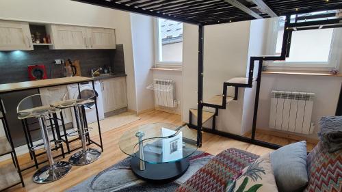 ein Wohnzimmer mit einem Sofa und einer Küche in der Unterkunft CHIC & MODERNE au coeur de la vie embrunaise in Embrun