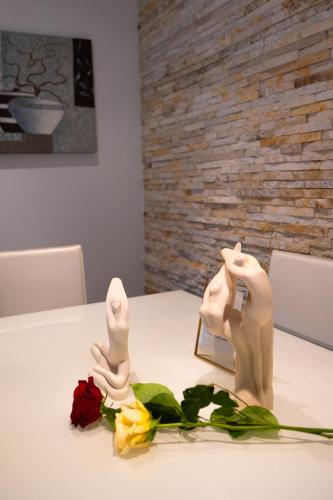 a table with a figurine and flowers on it at Hana apartament hot tub in Vlorë