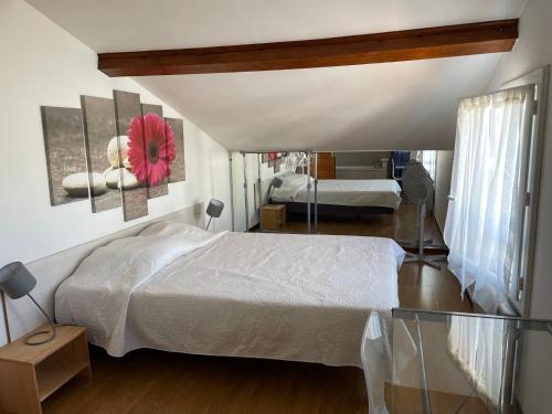 - une chambre avec 2 lits et une fleur rouge sur le mur dans l'établissement Mer Havre de Paix, à Pérols