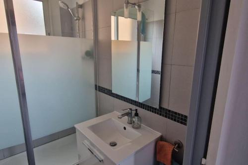 une salle de bain avec un lavabo et un miroir dans l'établissement T2-au calme-terrasse-place de parking attitrée, à Collioure