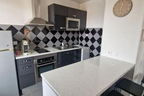 une cuisine avec un évier et une cuisinière four supérieur dans l'établissement T2-au calme-terrasse-place de parking attitrée, à Collioure