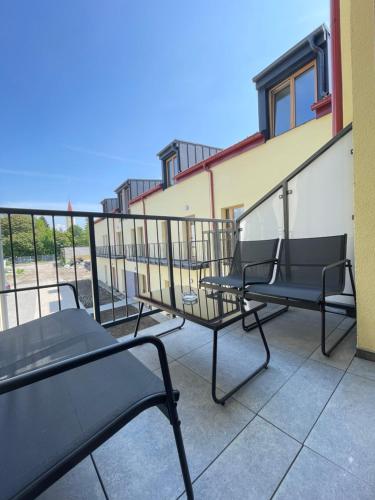a row of chairs on a balcony of a building at Royal Apartments Liptovsky Mikulas in Liptovský Mikuláš