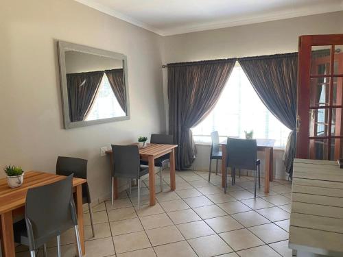 jadalnia ze stołem, krzesłami i lustrem w obiekcie Zacks Country Stay w mieście Krugersdorp