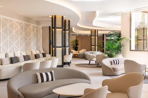 a lobby with couches and tables and chairs at Golden Bahía de Tossa & Spa 4* Sup. in Tossa de Mar