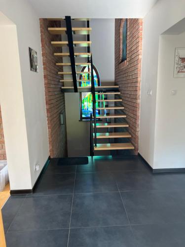 a staircase in a brick building with a stained glass window at Dom pod klonami in Szczytno