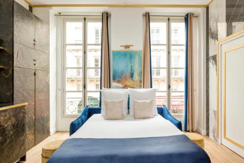 a bedroom with a blue bed and a window at Luxury 3 bedroom 2 bathroom apartment - Louvre in Paris