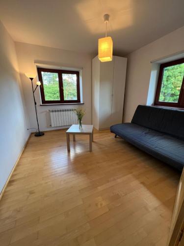 a living room with a couch and a table at Dom pod klonami in Szczytno