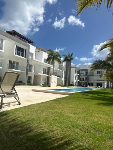 a chair in front of a building with a swimming pool at Estancia Mónaco, Hard Rock CANA BAY in Punta Cana