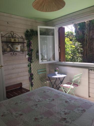 a room with a patio with a table and a window at Hôtel de la Tour in Les Sables-d'Olonne