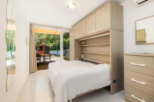 a bedroom with a bed and a sliding glass door at Sa Figuereta Beach in Playa de Muro