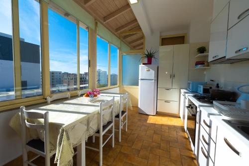 a kitchen with a table with chairs and a refrigerator at Hana apartament hot tub in Vlorë