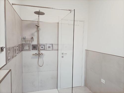um chuveiro com uma porta de vidro na casa de banho em Casa Giuseppe Castelsardo em Castelsardo