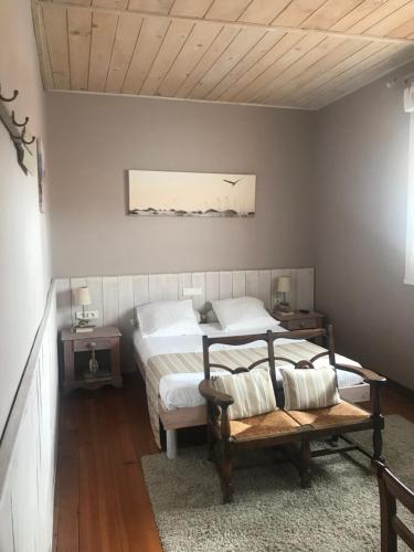 a bedroom with two beds and a bench in it at Hôtel de la Tour in Les Sables-d'Olonne